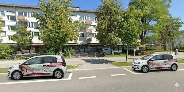 Front view of Ambulanter Pflegedienst in München with two company cars on the street.